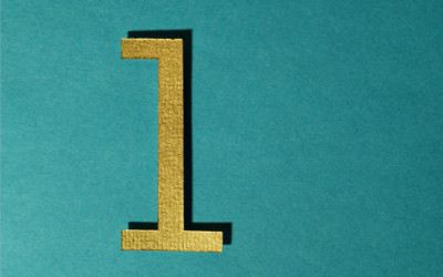 An image of a gold coloured number one on a green background